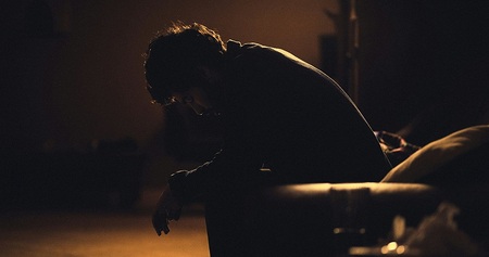 Mann im Dunkeln auf einer Bank