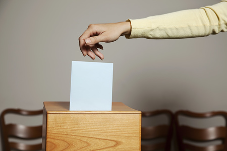Eine junge Frau bei einer Wahl in der Wahlzelle. Stimmabgabe in der Demokratie