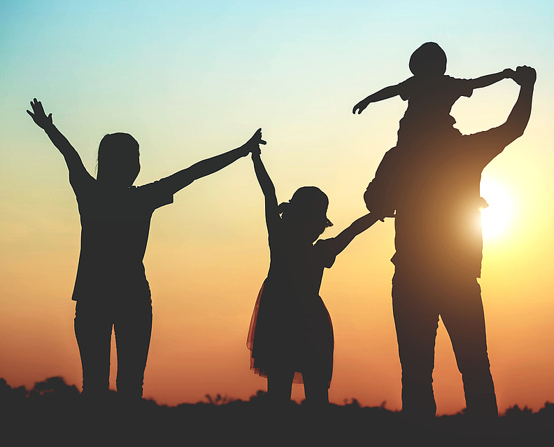 Silhouette of a family comprising a father, mother and two children happy family the sunset.Concept of friendly