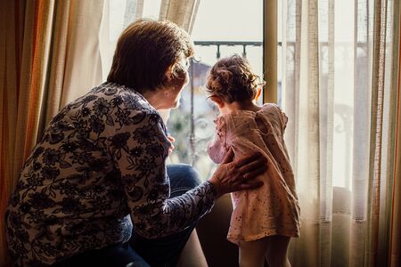 Großmutter mit Kind am Fenster